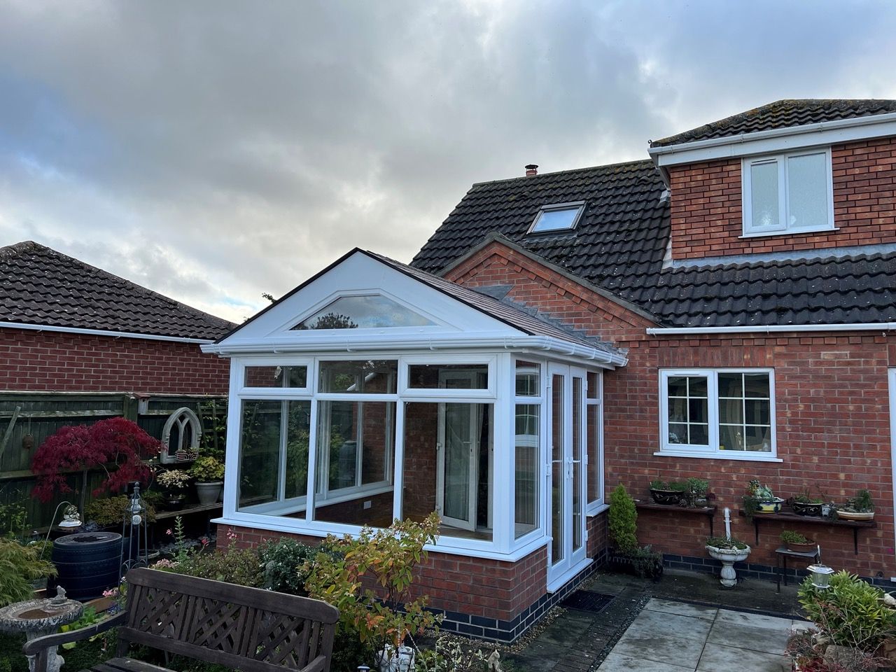 Conservatory with a warm roof in a planted garden
