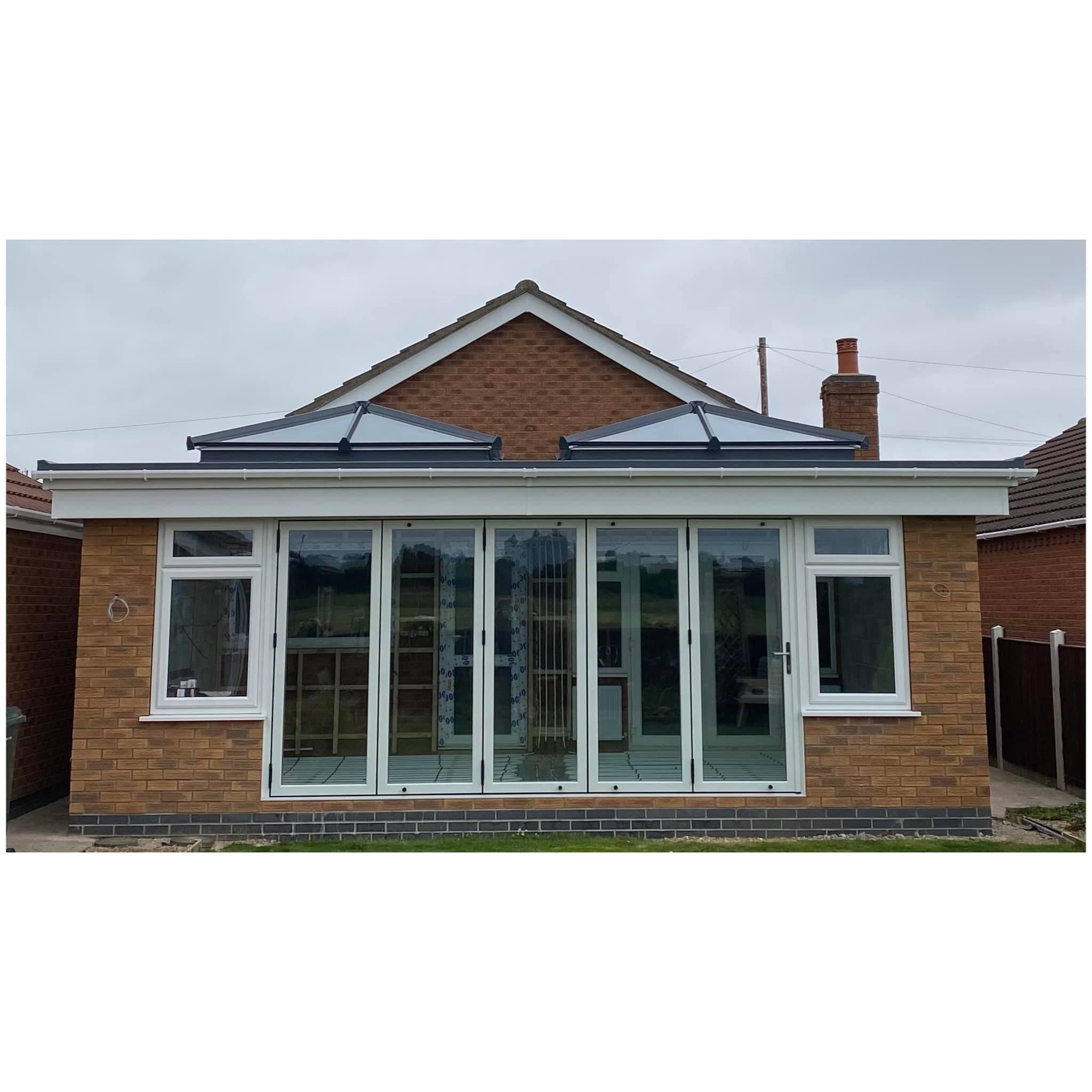 Single storey brick extension with two glazed roof lanterns and white bifolding doors