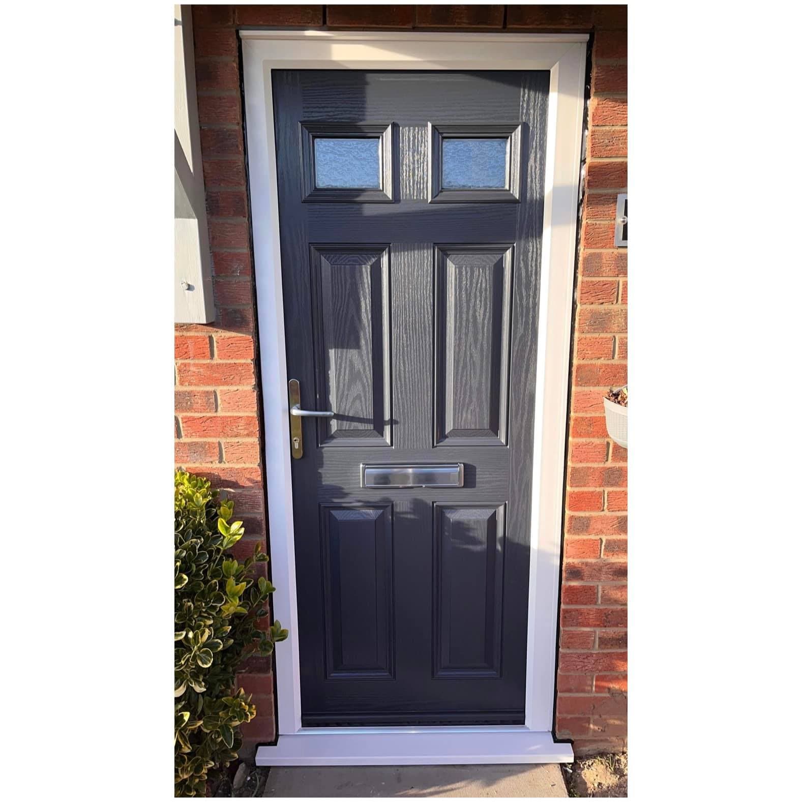 Dark blue panelled front door with two obscure glazed lights and a chrome letterplate