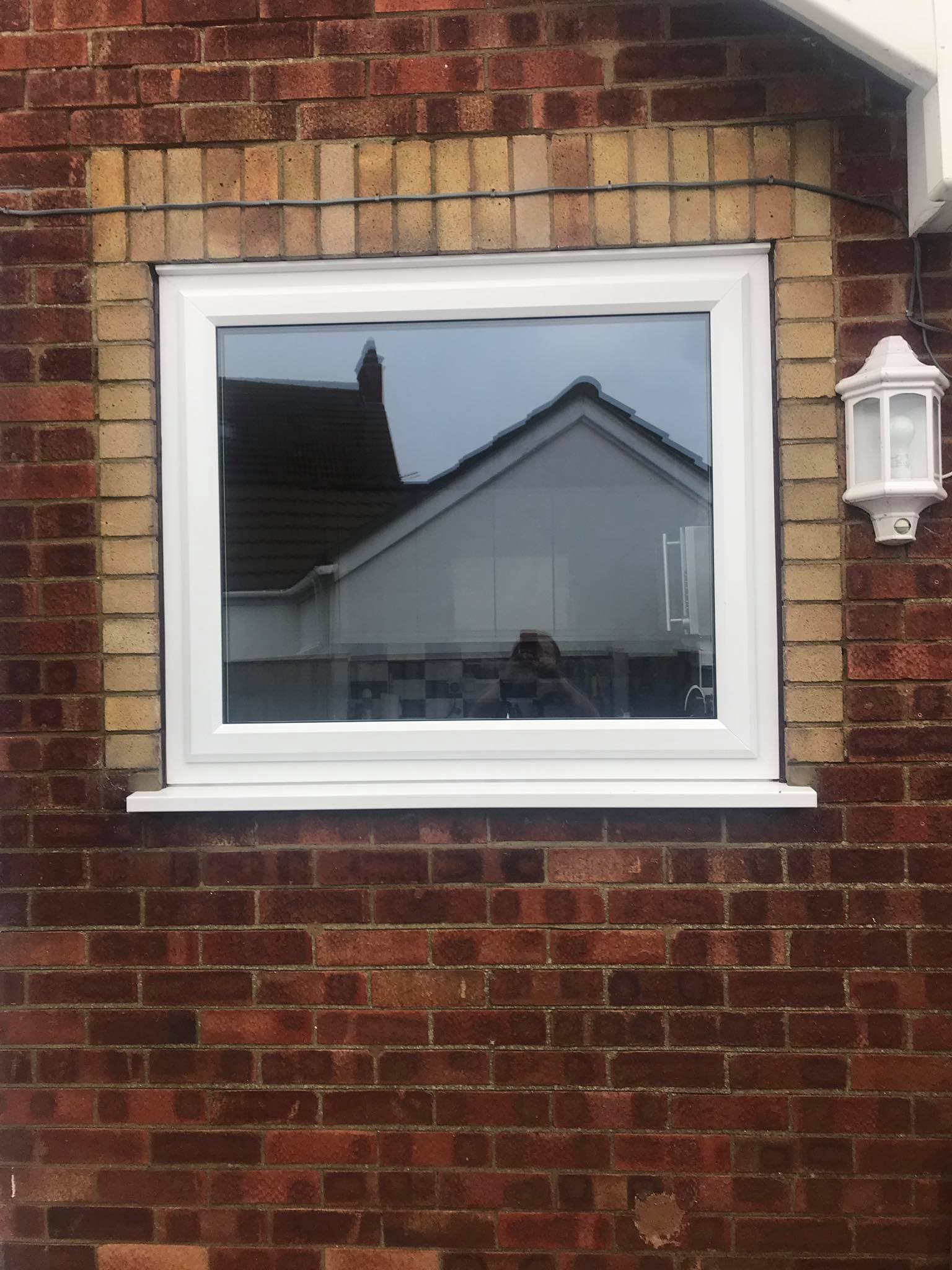 Large white fixed pane window in a red brick wall