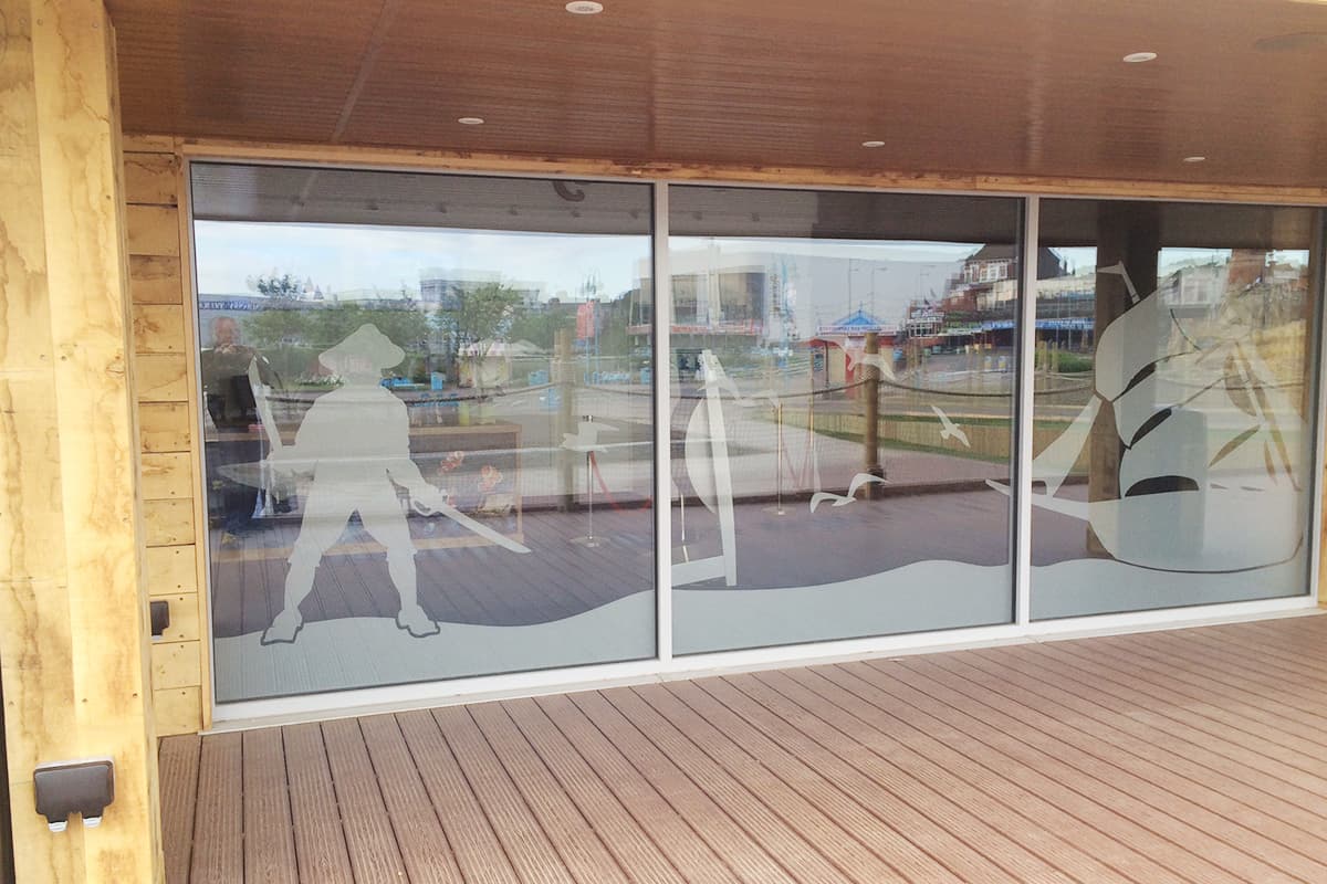 Large glazed panels with frosted seagull and sailing ship graphics on a timber clad frontage