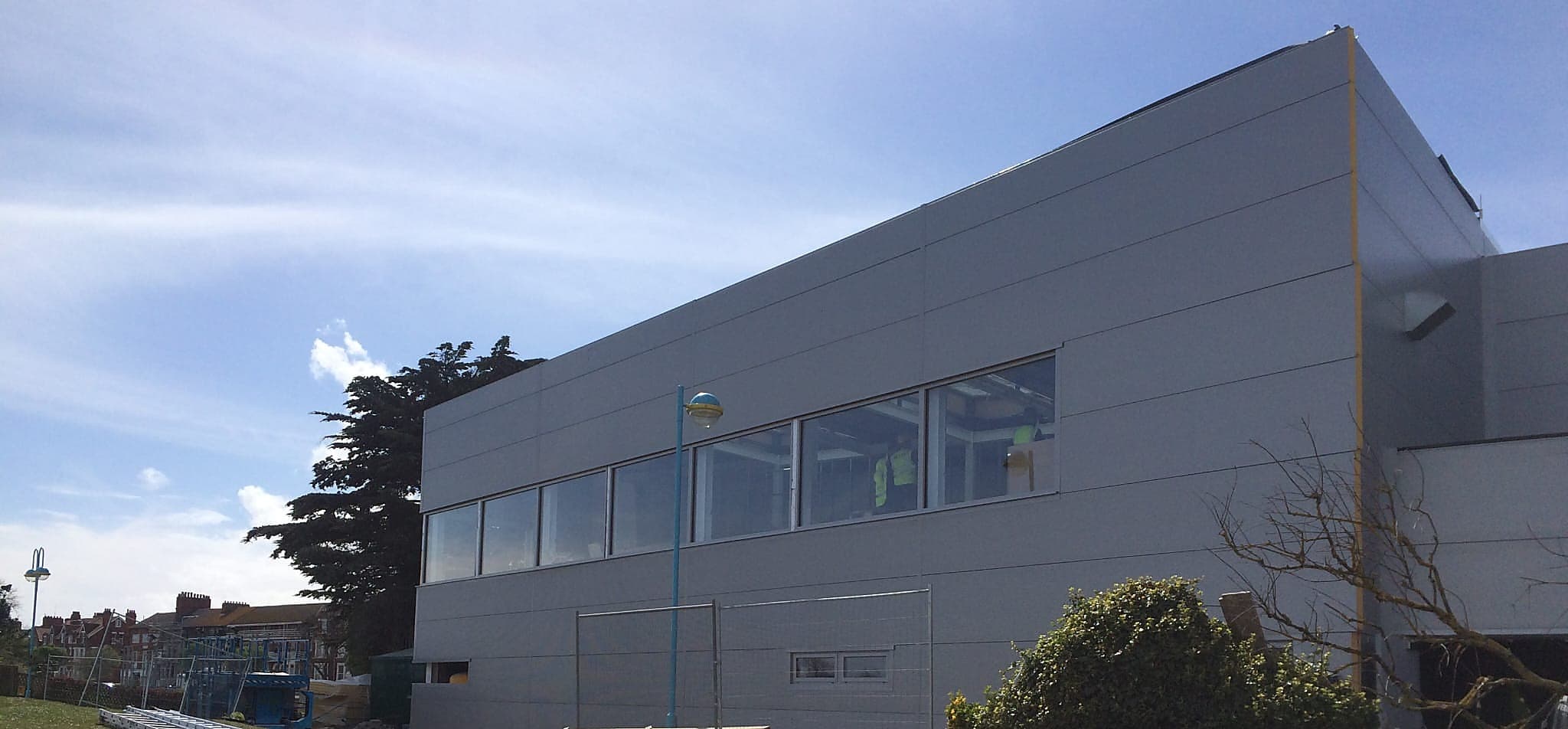 Panel clad commercial building with a horizontal run of framed glazing along the first floor