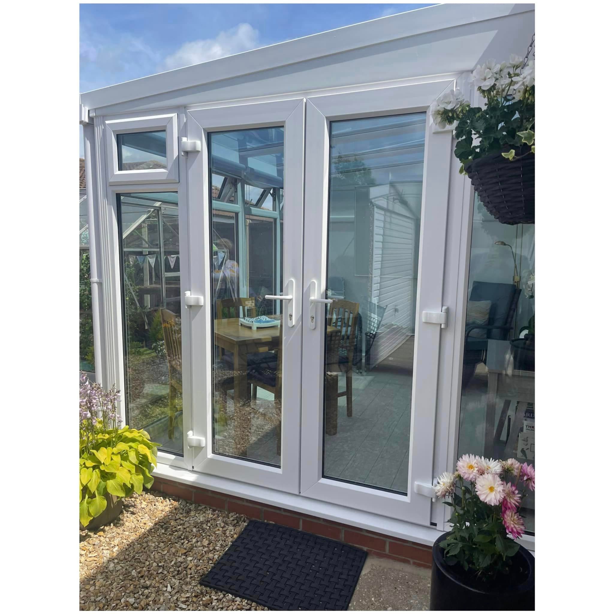White French doors with lever handles and glazed panels to either side