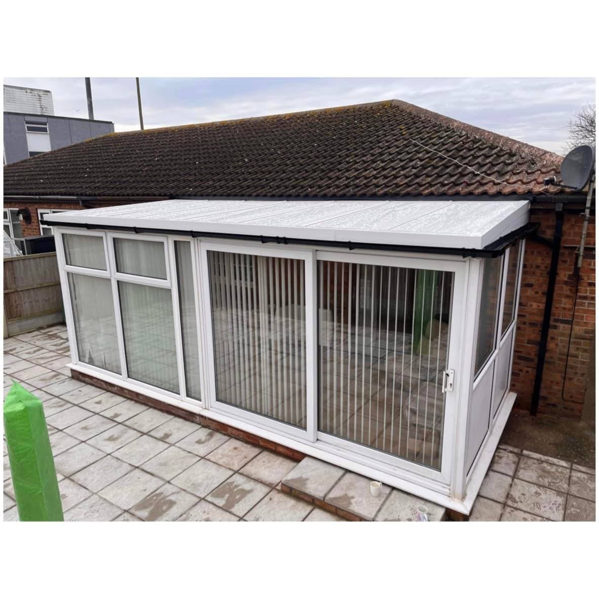 White framed lean to conservatory with a translucent roof on a low brick base