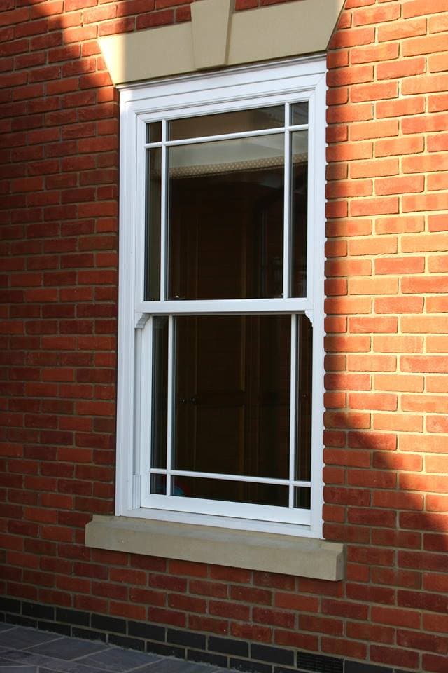 White sliding sash window with marginal glazing bars in a red brick wall